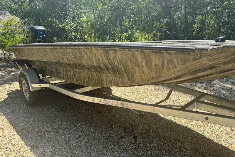 Slide: The Image of 2025 SeaArk 1752 Slayer Pro boat on trailer, camo design, parked outdoors. - 9