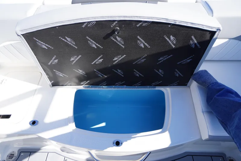 Slide: The Image of 2026 Chaparral 21 SSi OB boat storage compartment with open lid, showcasing interior space. - 42