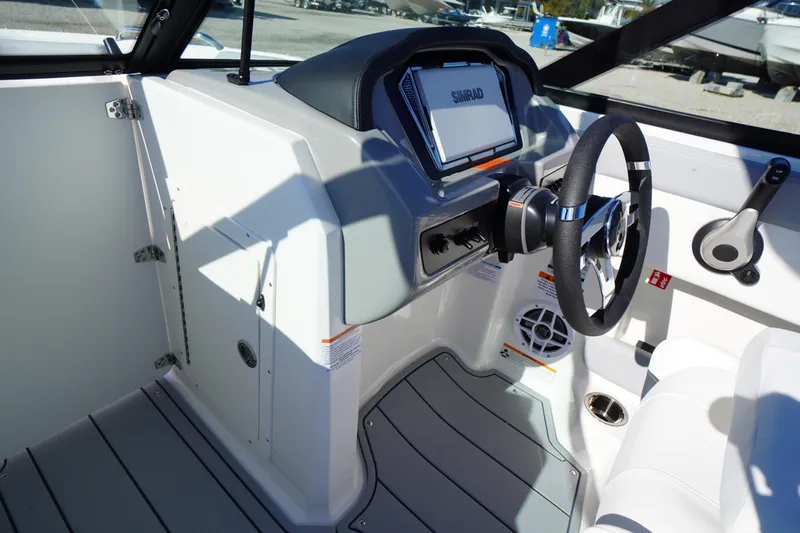 Slide: The Image of Interior of 2026 Chaparral 21 SSi OB boat, featuring steering wheel and control panel. - 18