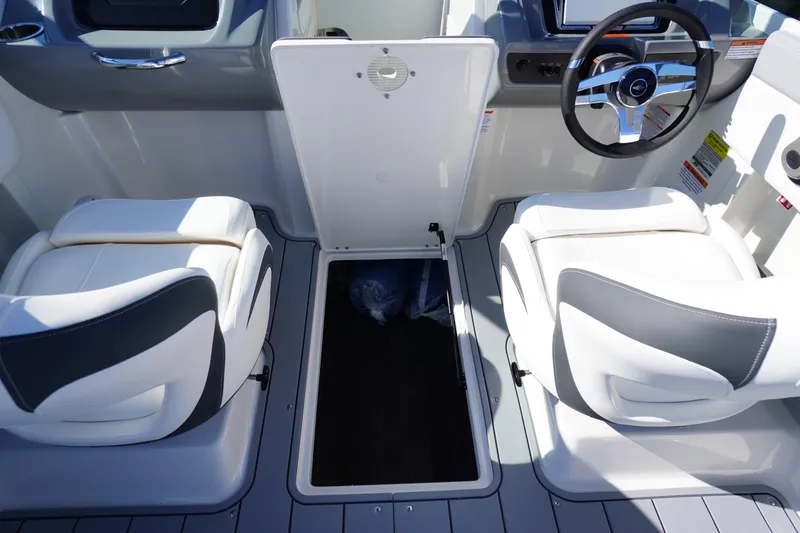 Slide: The Image of 2026 Chaparral 21 SSi OB boat interior with open storage compartment and dual seating. - 27