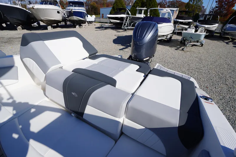 Slide: The Image of 2026 Chaparral 21 SSi OB boat with sleek seating and outboard motor in a marina. - 37