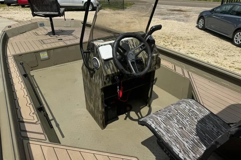 Slide: The Image of 2025 SeaArk Slayer Pro boat interior with camo design and steering console. - 13