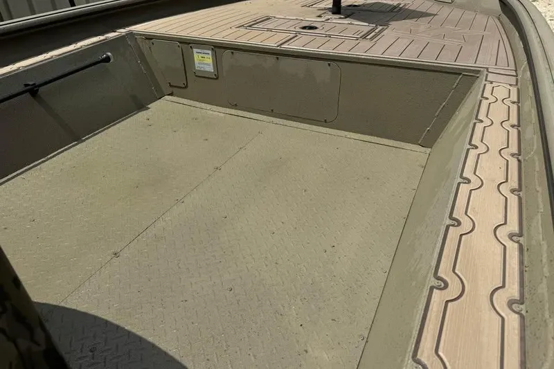 Slide: The Image of 2025 SeaArk Slayer Pro boat interior with textured flooring and storage compartments. - 14