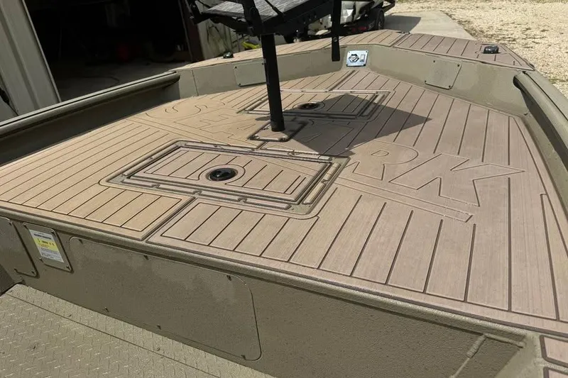 Slide: The Image of 2025 SeaArk Slayer Pro boat deck with storage compartments and textured flooring. - 15