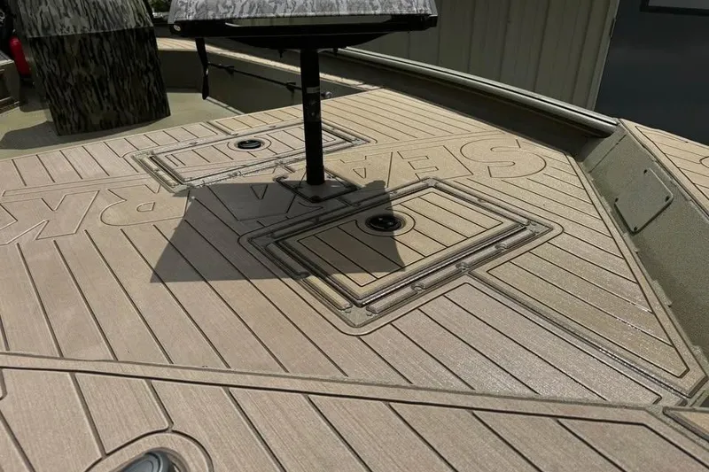 Slide: The Image of 2025 SeaArk Slayer Pro boat deck with storage compartments and textured surface. - 16