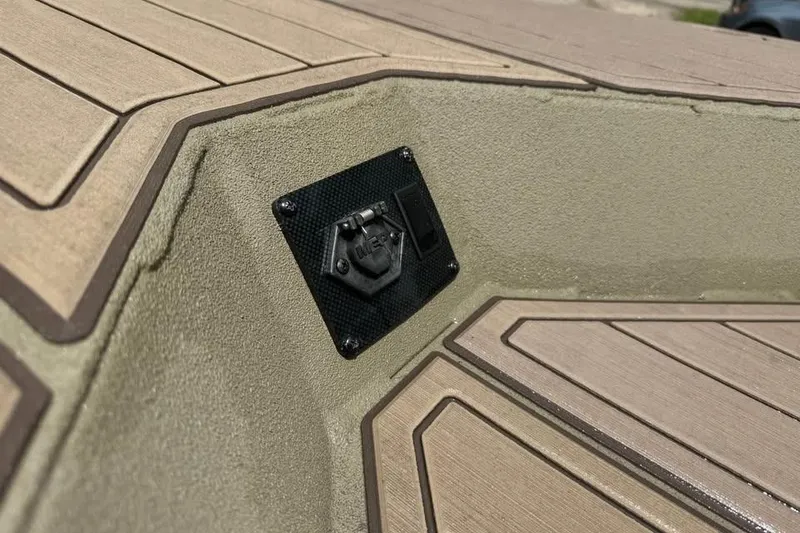 Slide: The Image of 2025 SeaArk Slayer Pro boat deck with textured surface and utility panel. - 17