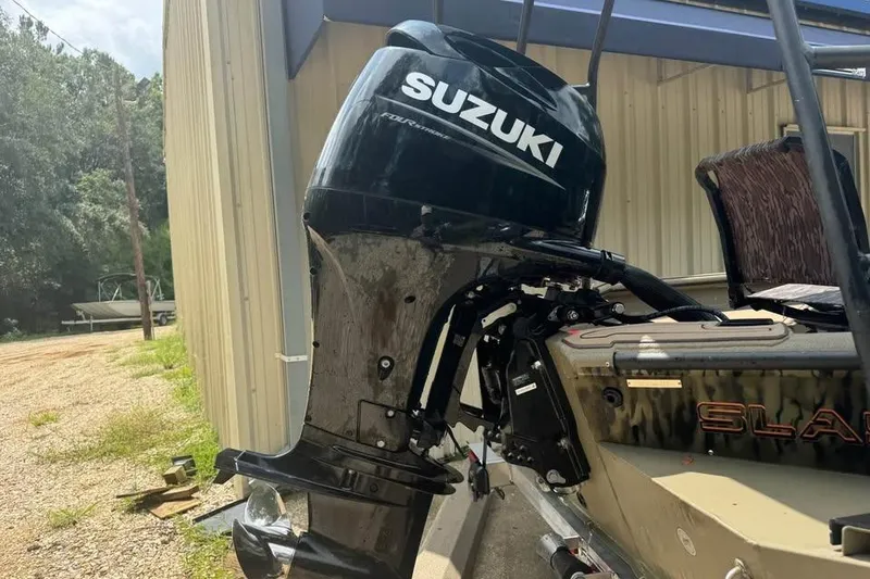 Slide: The Image of 2025 SeaArk Slayer Pro boat with Suzuki outboard motor, parked near a building. - 5