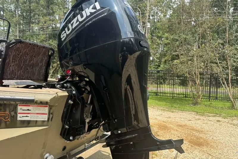 Slide: The Image of 2025 SeaArk Slayer Pro boat with Suzuki outboard motor in a wooded area. - 7
