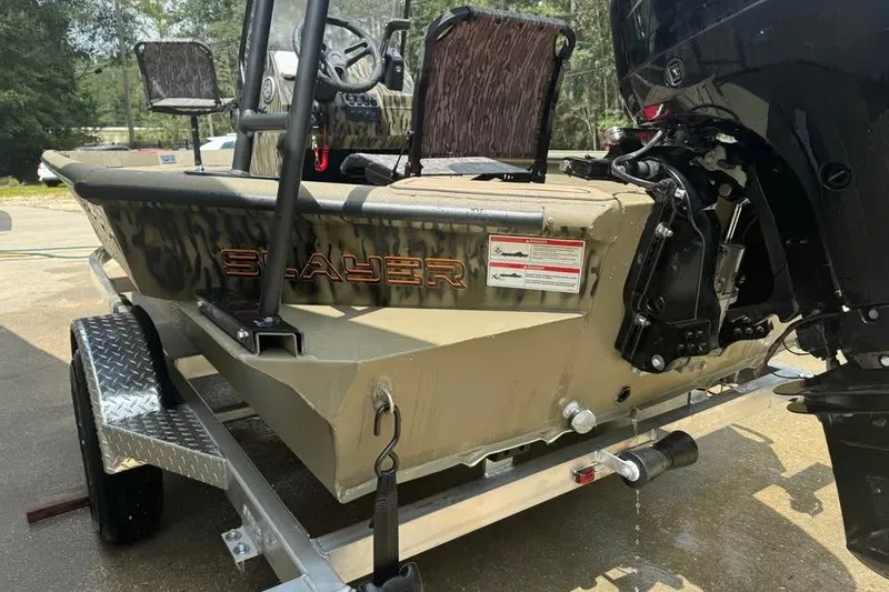 Slide: The Image of 2025 SeaArk Slayer Pro boat on trailer, rear view with motor and camo design. - 9