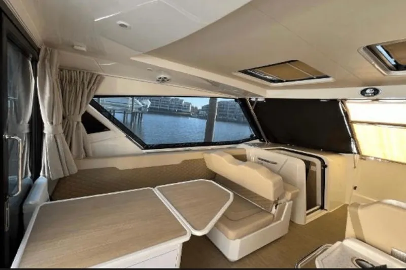 Slide: The Image of Interior of 2022 Aquila 36 Cruiser with seating and table, overlooking water. - 10