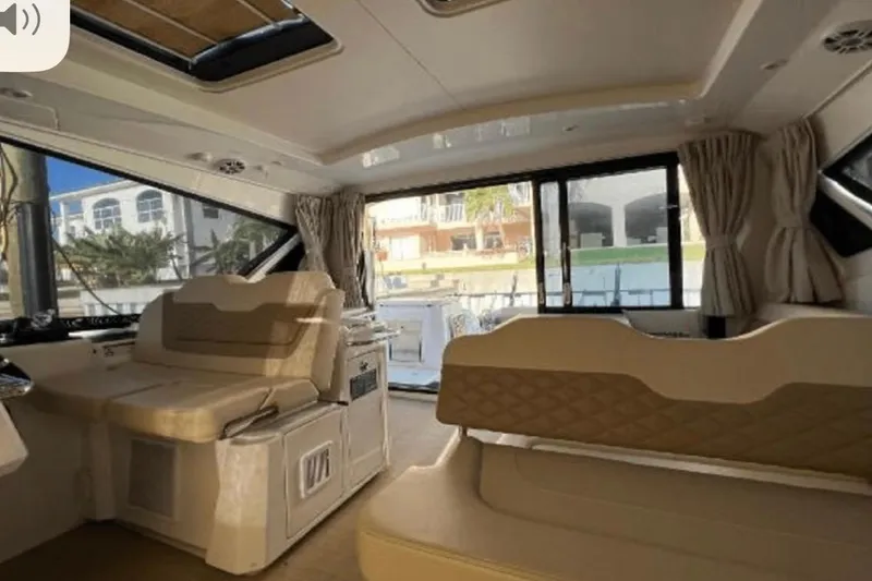 Slide: The Image of Interior of 2022 Aquila 36 Cruiser, featuring luxurious seating and large windows. - 16