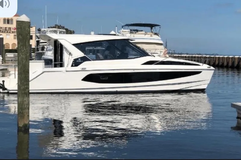 Slide: The Image of Aquila 36 Cruiser 2022 yacht docked in a marina, reflecting on calm water. - 2
