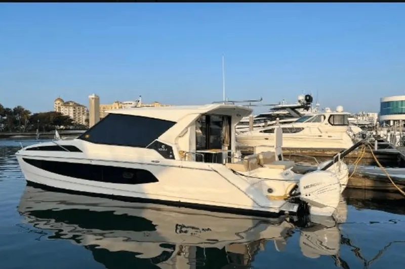 Slide: The Image of 2022 Aquila 36 Cruiser yacht docked in a marina under clear blue skies. - 3
