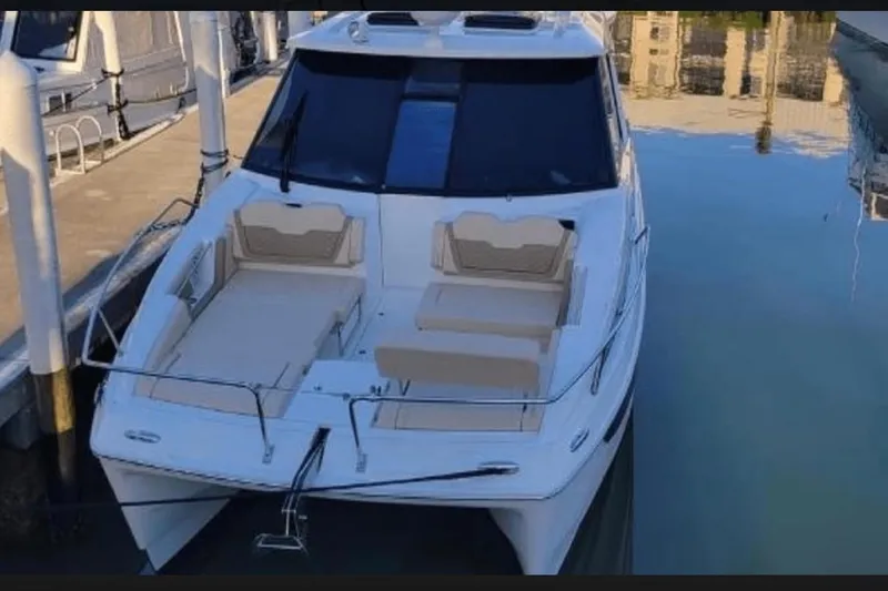 Slide: The Image of Aquila 36 Cruiser 2022 docked, featuring spacious deck seating and sleek design. - 6