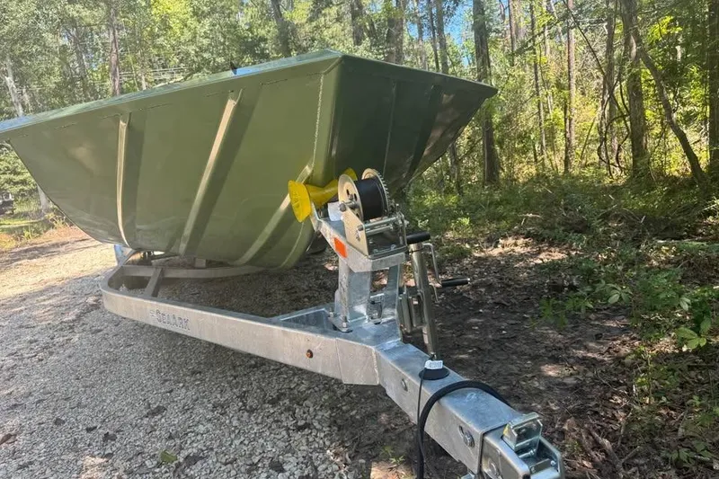 Slide: The Image of 2026 SeaArk 2672 MV boat on trailer in wooded area. - 14