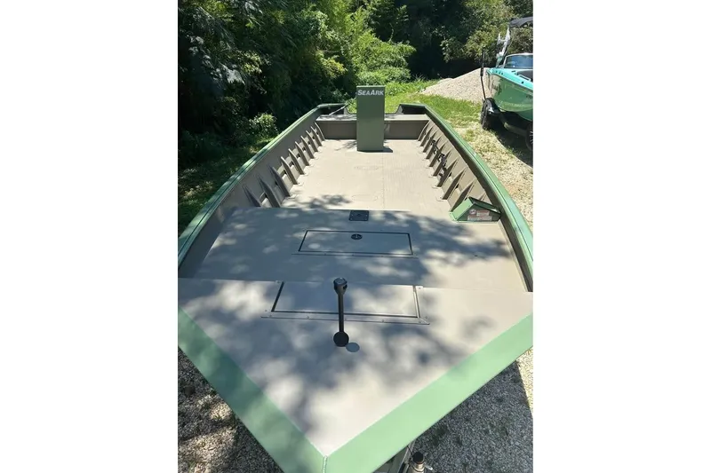 Slide: The Image of 2026 SeaArk 2672 MV boat with spacious deck, green exterior, and storage compartments. - 2