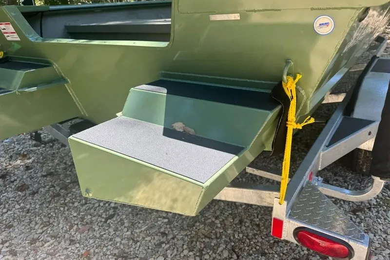 Slide: The Image of 2026 SeaArk 2672 MV boat on trailer, featuring green exterior and step platform. - 9