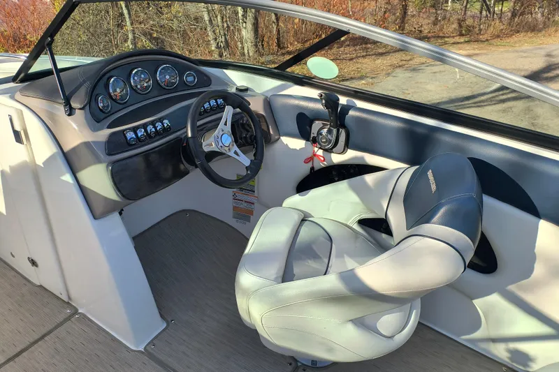 Slide: The Image of 2018 Rinker QX23 BR boat cockpit with steering wheel and control panel. - 10