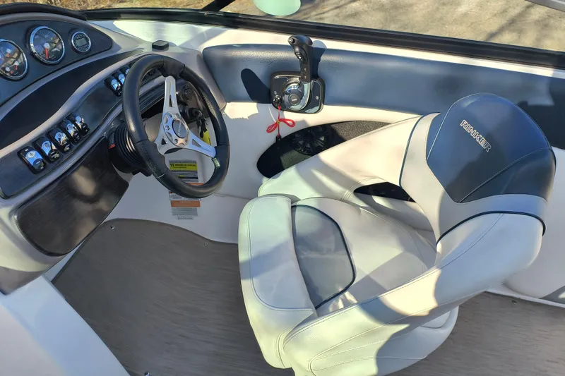 Slide: The Image of 2018 Rinker QX23 BR boat cockpit with steering wheel and control panel. - 11