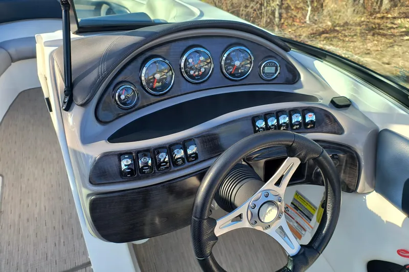Slide: The Image of 2018 Rinker QX23 BR boat dashboard with gauges and steering wheel. - 12