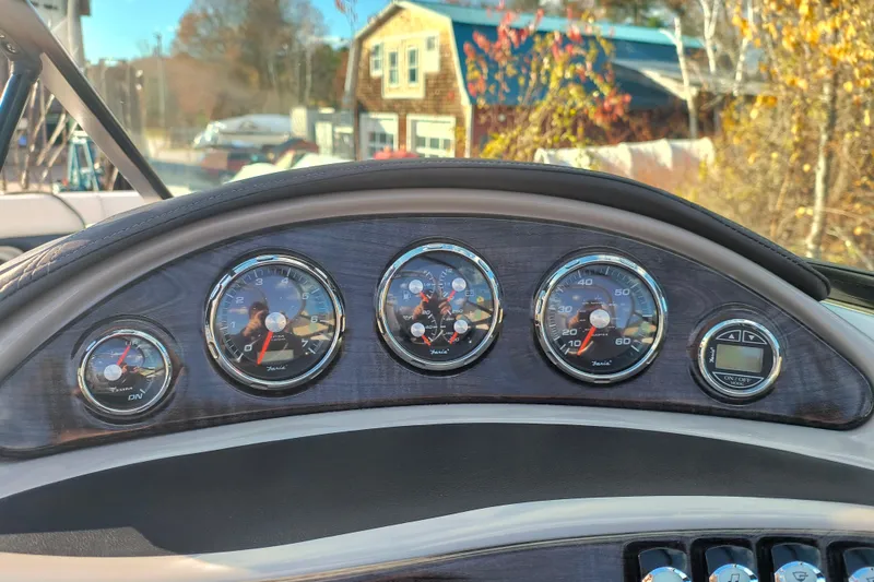 Slide: The Image of Dashboard of a 2018 Rinker QX23 BR boat with gauges and controls. - 14