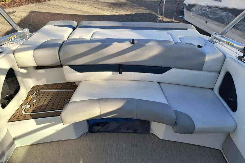 Slide: The Image of 2018 Rinker QX23 BR boat interior with cushioned seating and deck details. - 22
