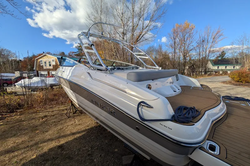Slide: The Image of 2018 Rinker QX23 BR boat on land, showcasing sleek design and spacious deck. - 3