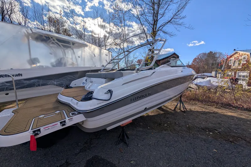 Slide: The Image of 2018 Rinker QX23 BR boat on display outdoors under a clear blue sky. - 4