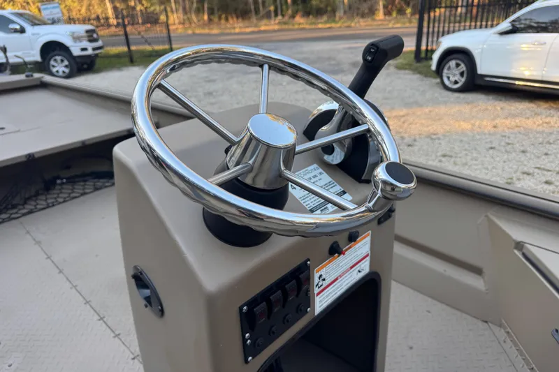 Slide: The Image of 2025 SeaArk Mud Runner 180 steering console with chrome wheel and controls. - 10