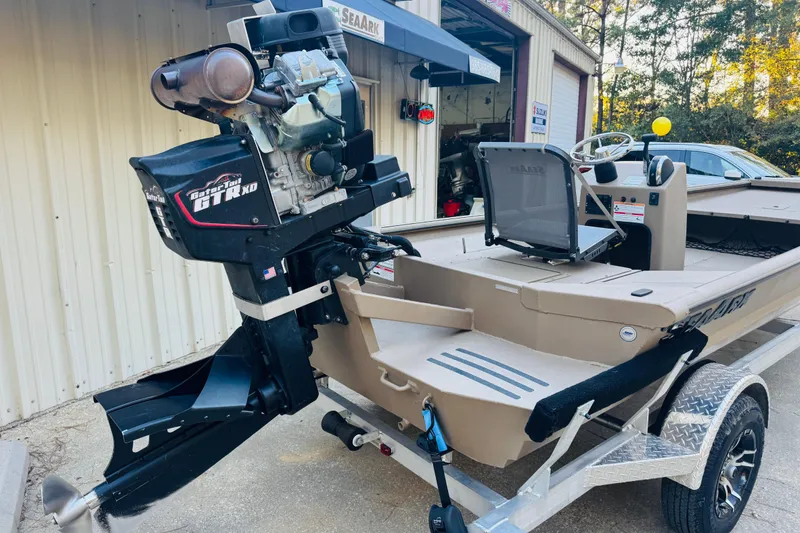 Slide: The Image of 2025 SeaArk Mud Runner 180 boat with Gator-Tail motor, parked on a trailer. - 13