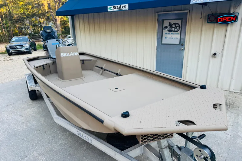 Slide: The Image of 2025 SeaArk Mud Runner 180 boat on trailer outside marine shop. - 17