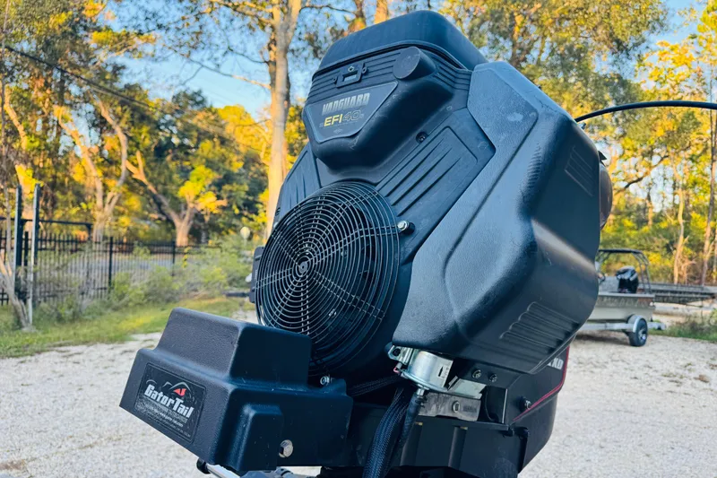 Slide: The Image of 2025 SeaArk Mud Runner 180 engine close-up with Gator Tail branding in outdoor setting. - 21