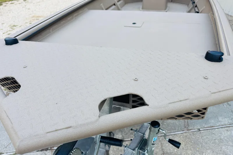 Slide: The Image of 2025 SeaArk Mud Runner 180 boat deck with textured surface and storage compartment. - 23