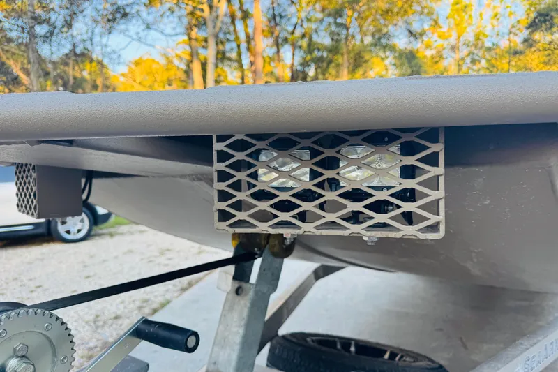 Slide: The Image of 2025 SeaArk Mud Runner 180 boat trailer detail with metal grid and winch. - 25