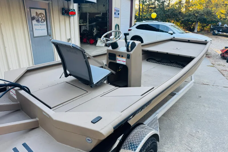 Slide: The Image of 2025 SeaArk Mud Runner 180 boat parked outside a marine shop. - 6
