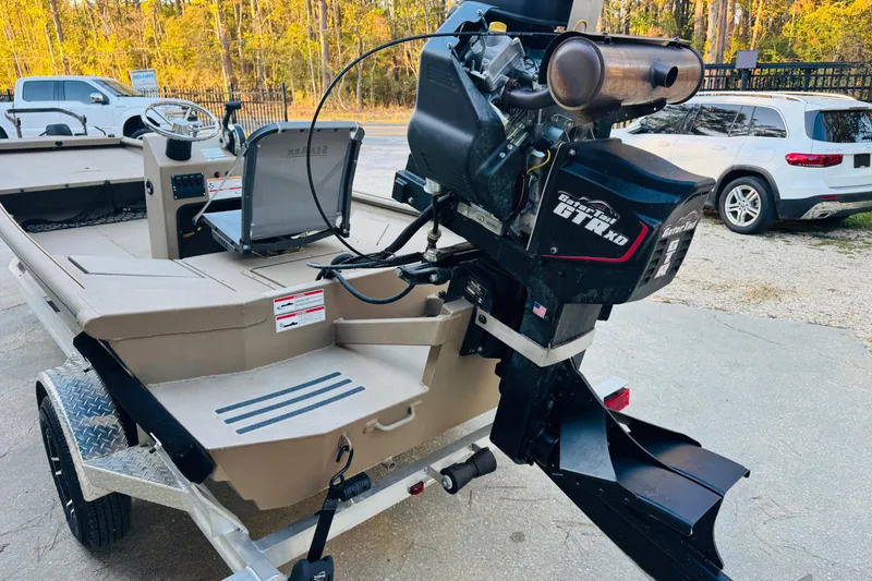 Slide: The Image of 2025 SeaArk Mud Runner 180 boat with powerful motor, parked on a trailer. - 7