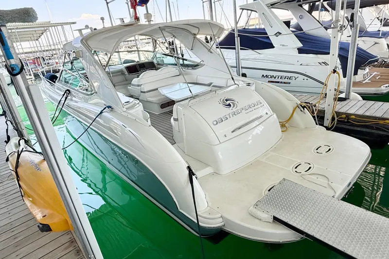 Slide: The Image of 2004 Formula 400 Super Sport yacht docked at marina, featuring sleek design and spacious deck. - 30