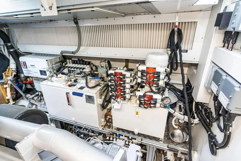 Slide: The Image of Engine room of a 2019 Pershing 9X yacht, showcasing complex machinery and wiring. - 105