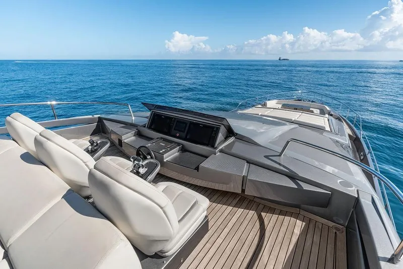 Slide: The Image of Luxurious 2019 Pershing 9X yacht deck with helm, overlooking serene ocean waters. - 17