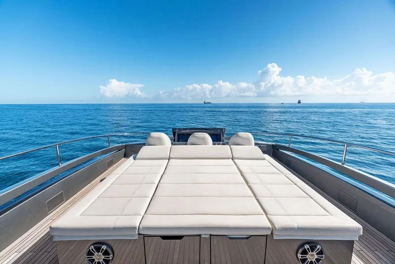 Slide: The Image of Luxurious 2019 Pershing 9X yacht deck with sunbed, ocean view, and clear blue sky. - 25
