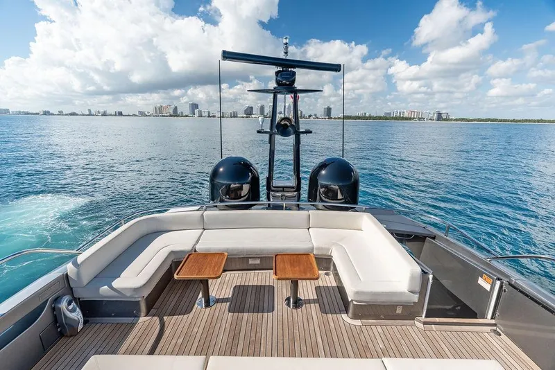 Slide: The Image of Luxury 2019 Pershing 9X yacht deck with seating, ocean view, and city skyline. - 27