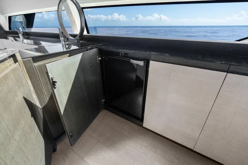 Slide: The Image of Luxurious 2019 Pershing 9X yacht interior with open cabinets and ocean view. - 52
