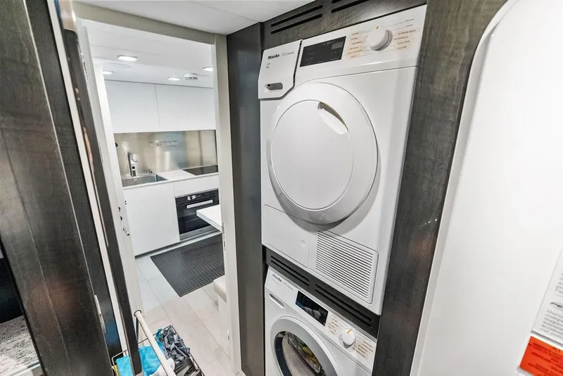 Slide: The Image of Laundry area and modern kitchen inside a 2019 Pershing 9X yacht. - 85
