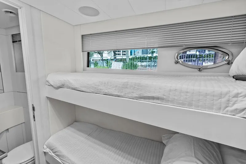 Slide: The Image of Bunk beds in a 2019 Pershing 9X yacht cabin with window view. - 89