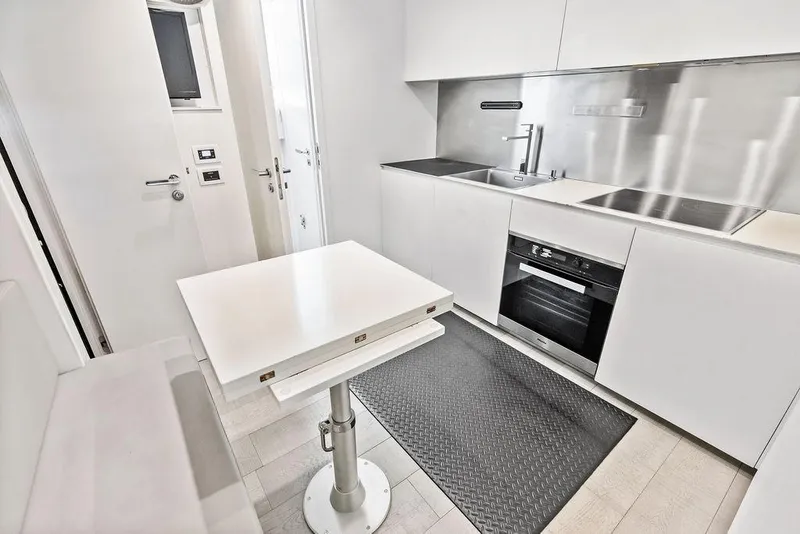 Slide: The Image of Modern kitchen interior on 2019 Pershing 9X yacht, featuring sleek white cabinetry and appliances. - 91