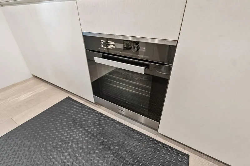 Slide: The Image of Modern kitchen with built-in oven, sleek cabinetry, and textured floor mat. - 93