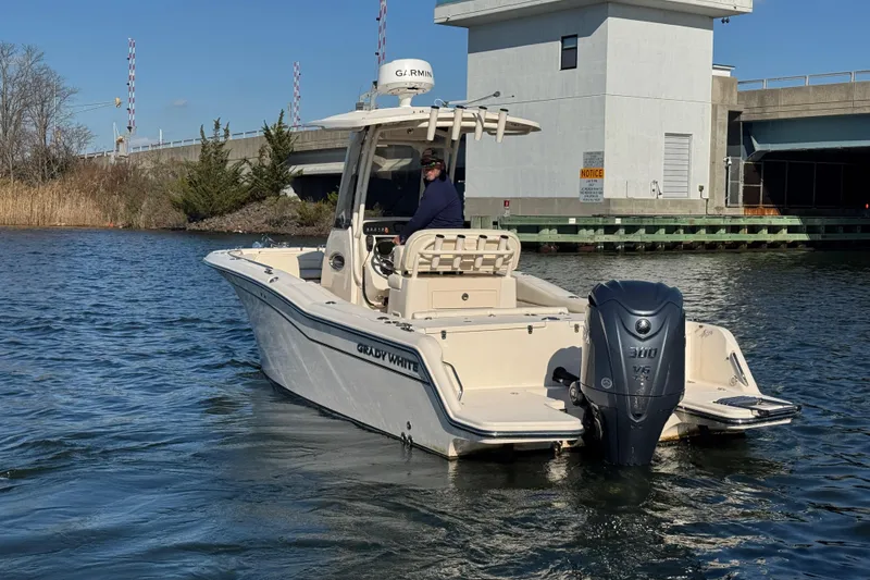 Slide: The Image of 2023 Grady-White Fisherman 236 boat on water near a bridge, featuring a powerful outboard motor. - 9