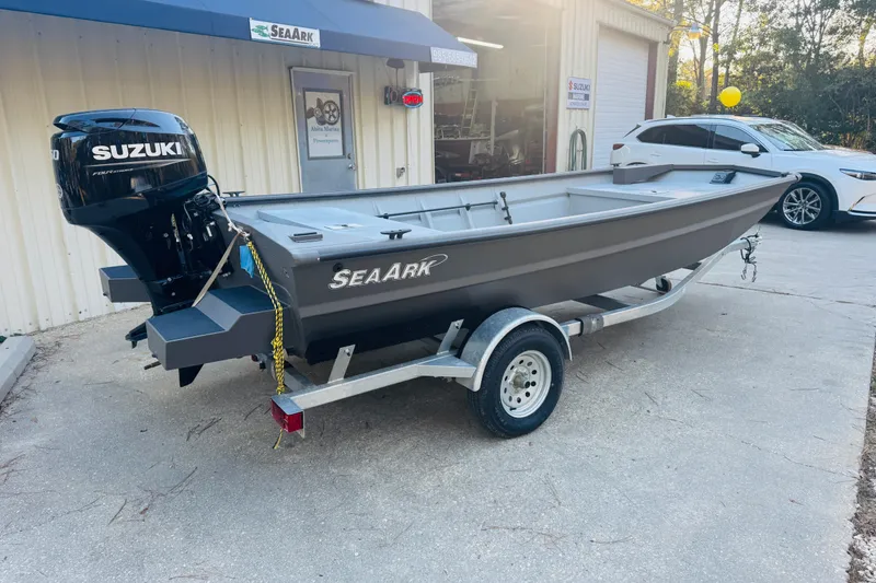 Slide: The Image of 2025 SeaArk 1660 MVT boat with Suzuki motor on a trailer outside a building. - 18