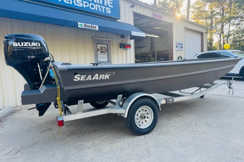Slide: The Image of 2025 SeaArk 1660 MVT boat with Suzuki engine on trailer outside marine shop. - 8