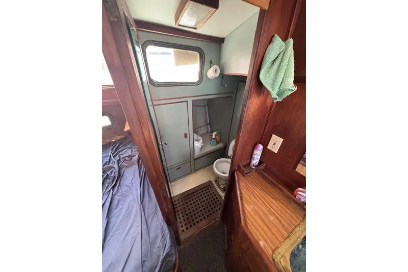 Slide: The Image of 1973 Maple Leaf Center Cockpit interior with bathroom, wooden cabinetry, and nautical decor. - 10